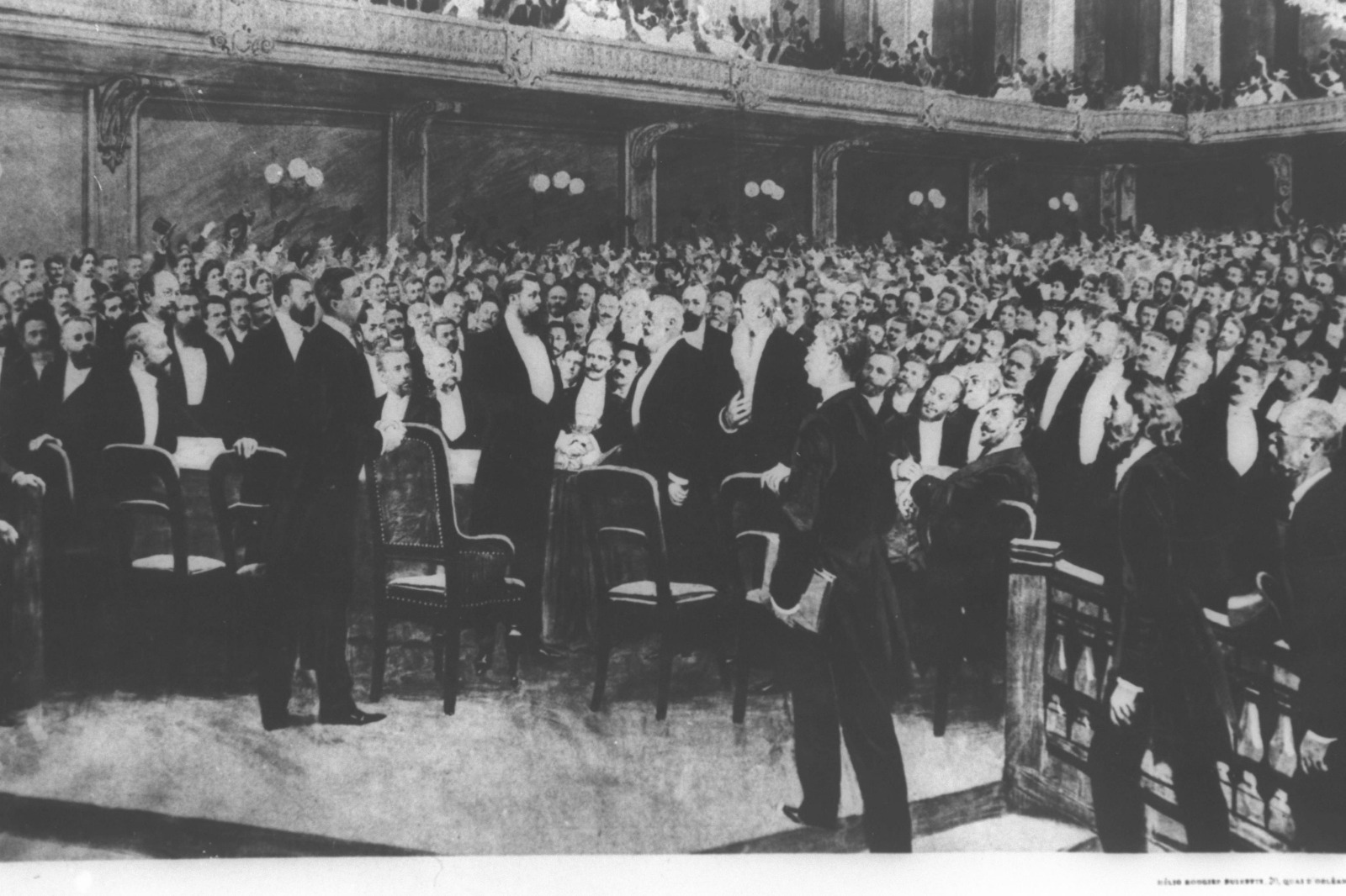 hotographie historique du premier congrès sioniste de Bâle montrant une grande assemblée d’hommes en tenue formelle réunis dans une salle de conférence autour de la tribune centrale.