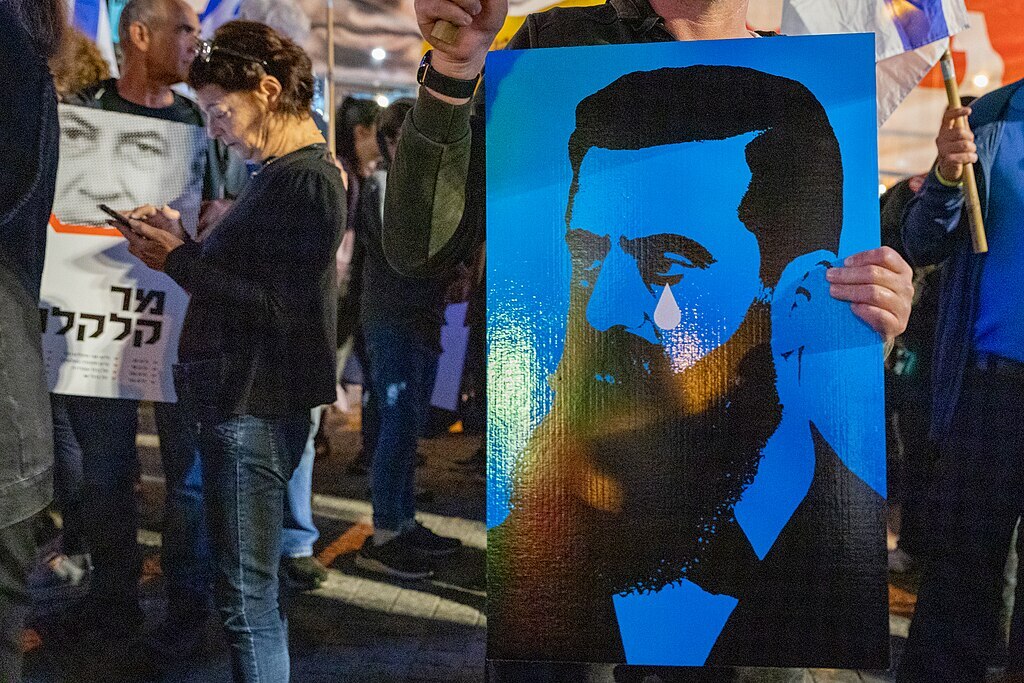 Poster of Theodor Herzl shedding a tear, held aloft during a demonstration in Tel Aviv in 2023.